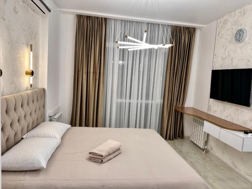 een slaapkamer met een groot bed met een groot raam bij Elen's Bi Residence in Batoemi