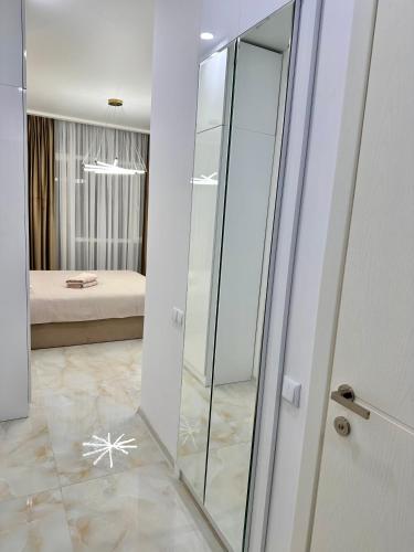 a bathroom with a glass shower and a bedroom at Elen's Bi Residence in Batumi