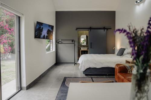 Heather Road Cottages في جورج: غرفة نوم بها سرير ومرآة