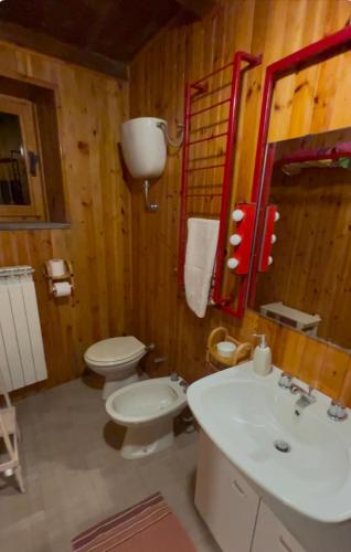 a bathroom with a white toilet and a sink at La casa di Delia in Castelpizzuto