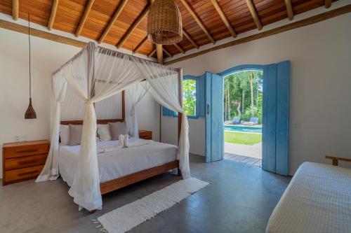 a bedroom with a bed with a mosquito net at Casa Theo Trancoso in Trancoso