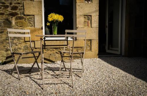 2 chaises et une table avec un vase de fleurs dans l'établissement Maison de vacances bord de mer tout à pied, à Binic