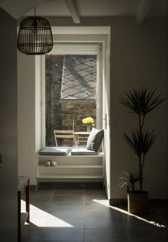 un siège de fenêtre dans une pièce avec une plante en pot dans l'établissement Maison de vacances bord de mer tout à pied, à Binic