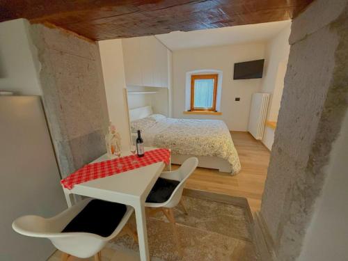 Un dormitorio con una cama y una mesa y sillas. en Casa Colibrì - a few steps from the ski slopes, en Forni di Sopra