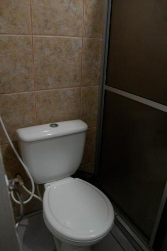 a bathroom with a white toilet and a shower at Casa Aeroporto Pousada in Recife