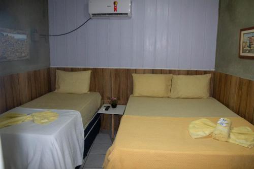 a room with two beds and a table at Casa Aeroporto Pousada in Recife