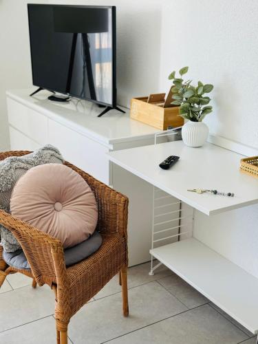 a room with a chair and a desk with a tv at Haus am Wasserturm Gästezimmer in Schorndorf-Schlichten in Schorndorf