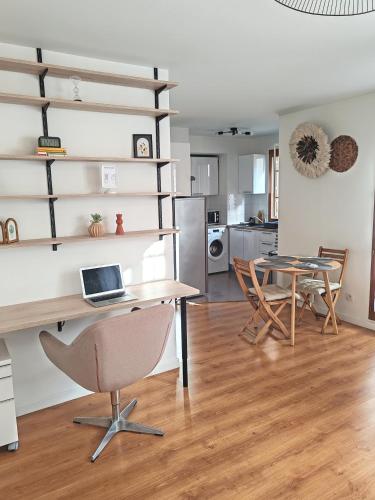 un salon avec un bureau et une table avec un ordinateur portable dans l'établissement Le Cocon Stade de France - Aux Portes de Paris - Parking Inclus, à Saint-Denis