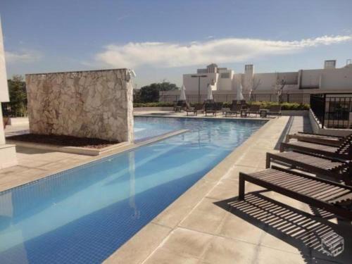 a large swimming pool with chairs and a building at Apartament 11th floor in Rio de Janeiro