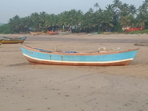 a boat sitting on the sand on a beach at Shantadurga Beachside Homestay in Guhagar