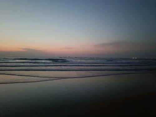 a view of the beach at sunset with the ocean at Shantadurga Beachside Homestay in Guhagar
