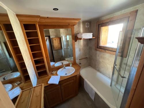 La salle de bains est pourvue d'une baignoire, d'un lavabo et d'une baignoire. dans l'établissement Meralouva 1650 Domaine de l Ariondaz Courchevel, à Courchevel