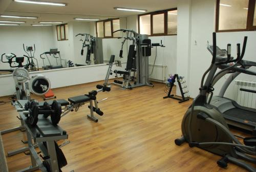 a gym with several treadmills and exercise bikes at Apart Hotel Comfort in Bansko