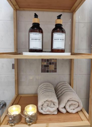 two bottles of shampoo and towels on a shelf in a bathroom at Camiño dos faros Malpica in Malpica