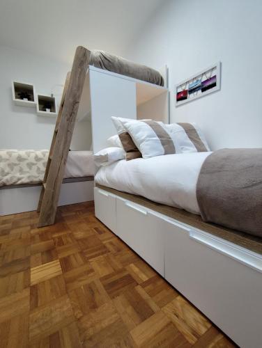 a bedroom with a large bed and wooden floors at Camiño dos faros Malpica in Malpica