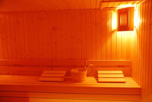 a sauna with three towels and a bucket in it at Apart Hotel Comfort in Bansko