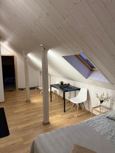 a room with a table and chairs in a attic at Villa Midesta in Šiauliai