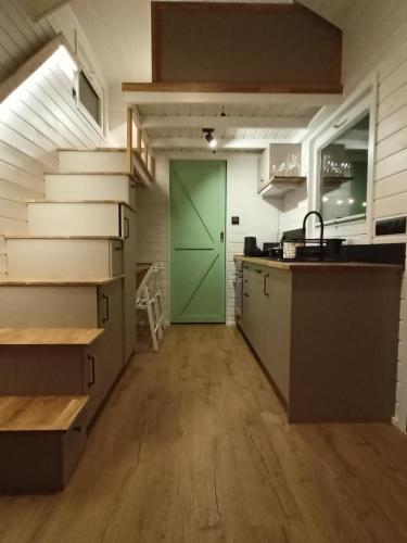 a kitchen with a green door in a room at Tiny house in the forest in Szlachta