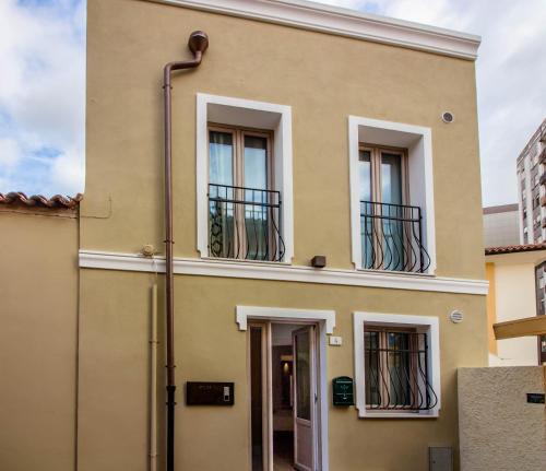 a yellow building with windows and a door at P&M Belvedere Rooms in Olbia