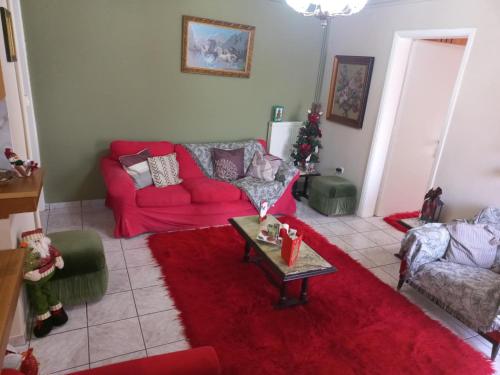 a living room with a red couch and a red rug at Mountain View in Feneos
