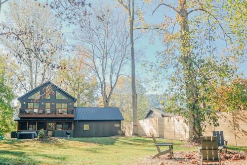 a house on a grassy field next to a building at Little River Retreat in Townsend