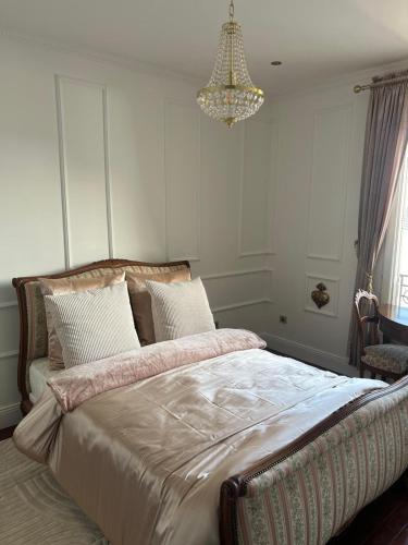 - une chambre avec un grand lit et un lustre dans l'établissement Charming Stay, à Saint-Ouen