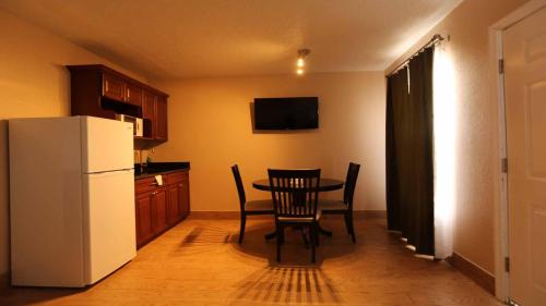 a kitchen with a table and a white refrigerator at Inn on the Gulf in Hudson