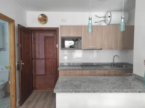 a kitchen with wooden cabinets and a counter top at Apartamento Sietu Caletillas in Santa Cruz de Tenerife