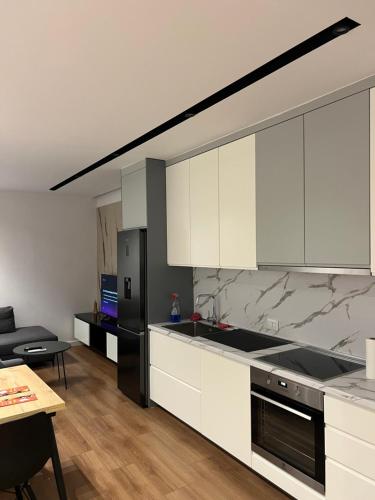 a kitchen with white cabinets and a black refrigerator at Renas apartment1 in Tirana
