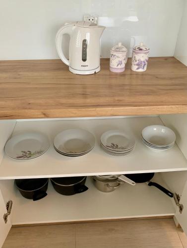 a tea kettle and plates on a shelf at Aura Home in Grywałd
