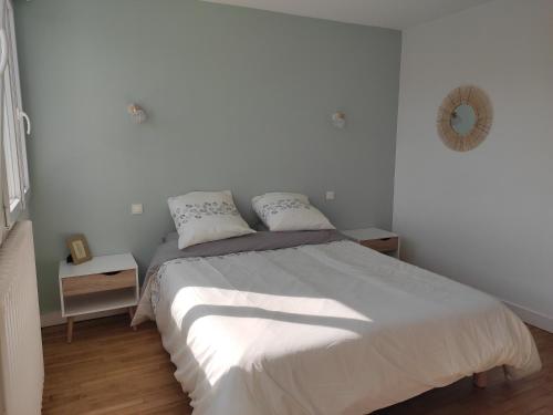 - une chambre blanche avec un grand lit et 2 oreillers dans l'établissement Maison 800 m de la plage pour 9 personnes, à Saint-Gildas-de-Rhuys