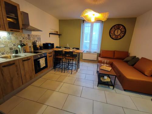 un salon avec un canapé et une cuisine dans l'établissement L'escapade d'Henry Dunant, à Épernay