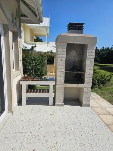 a outdoor fireplace with a bench next to a house at Caribbean Estates Villa Becca- Brand new- Pinnacle of Luxury in Port Edward