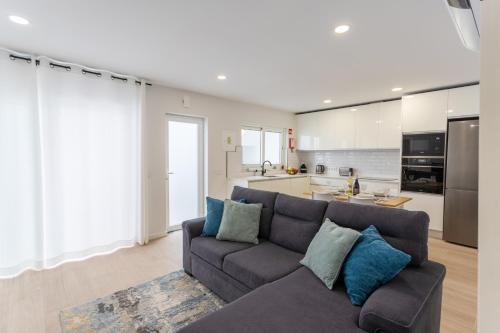 a living room with a couch and a kitchen at Casa da Colina in Ferragudo