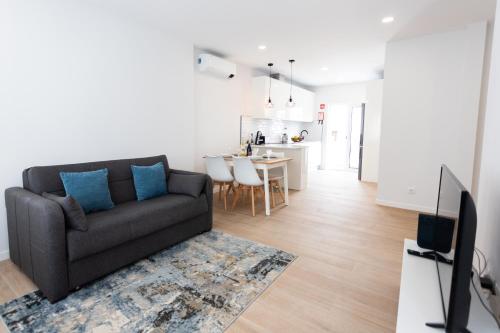 a living room with a couch and a kitchen at Casa da Colina in Ferragudo