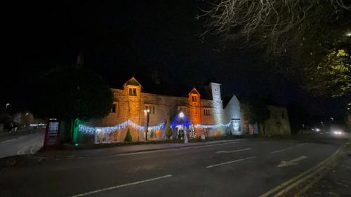 a lit up building with christmas lights on it at The Old Manor House Hotel in Keynsham