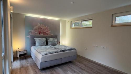 a bedroom with a bed and two windows on the wall at Klimaanlage, 5 Sterne Villa Bahnhoftraum, plus NEU zubuchbares Event, 333 qm, 1200qm Garten, virtueller Rundgang, Dachterrasse, Whirlpoolbadewanne in Braunfels