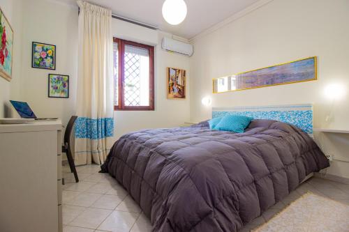 a bedroom with a bed with a purple blanket at Casa Aurora in Sassari