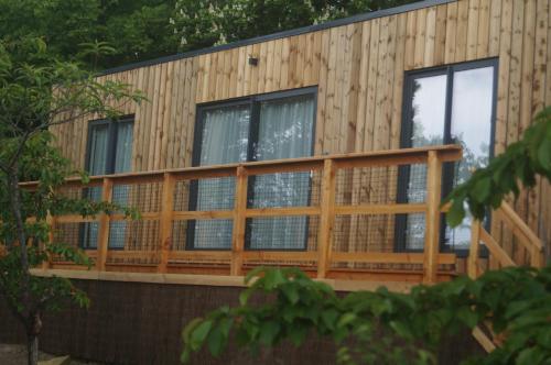 a house with a wooden deck and windows at Lodges Arverne in Vic-le-Comte