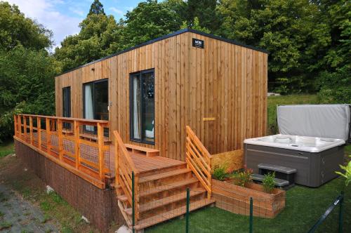 a wooden cabin with a hot tub on a deck at Lodges Arverne in Vic-le-Comte