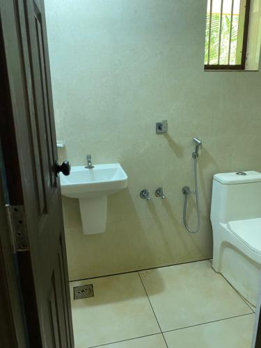 a bathroom with a sink and a toilet at Gaya beach hacienda in Irimbranallūr