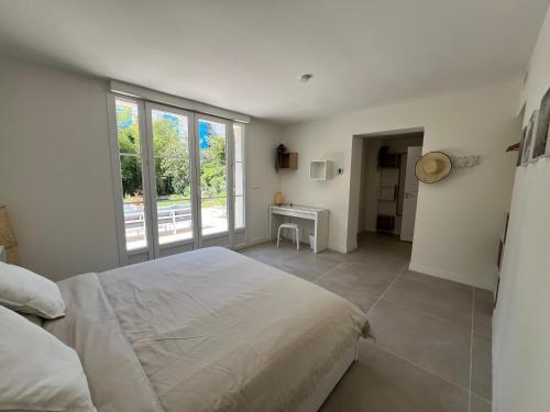 une chambre avec un lit et une grande fenêtre dans l'établissement Splendide maison Solstice, à Cannes