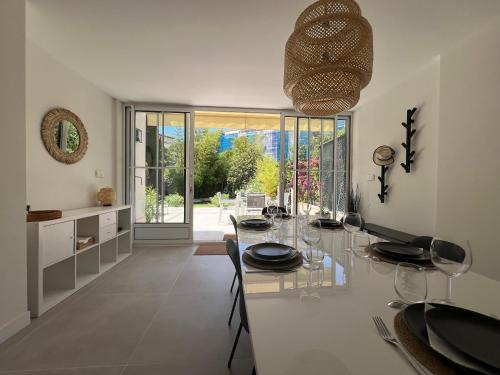une cuisine et une salle à manger avec une table en verre dans l'établissement Splendide maison Solstice, à Cannes
