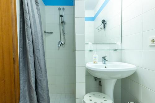 a white bathroom with a sink and a shower at Hotel Il Lato Azzurro - Isola di Sant'Erasmo - NO VEHICLES ACCESS in Venice