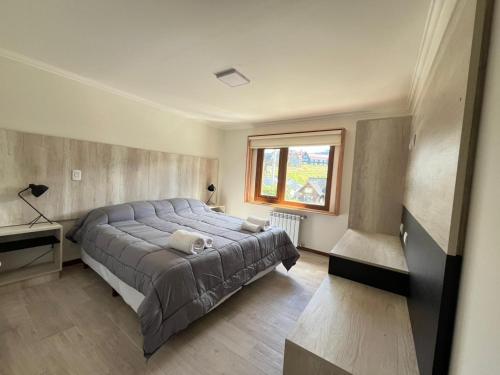 a bedroom with a large bed and a window at De los Tres in El Chalten
