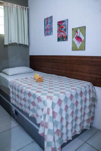 a bedroom with a bed with a white and pink comforter at Casa da Esquina Pousada in Recife