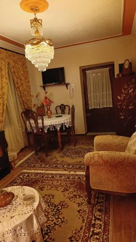 a living room with a table and a chandelier at Traditional house at Pelion seaside in Agria