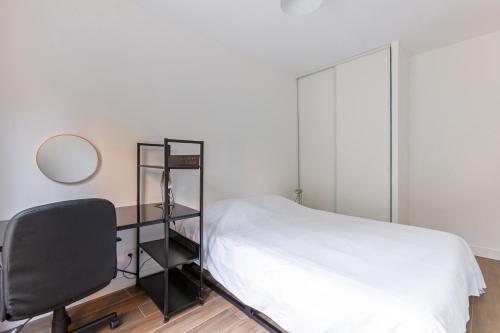 a bedroom with a bed and a desk and a chair at L'Escapade Paris in Le Kremlin-Bicêtre
