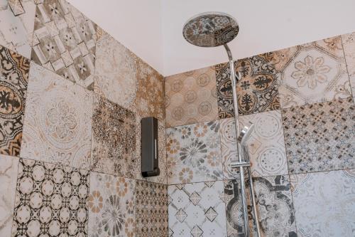 a shower in a bathroom with tiles on the wall at La Faustina Aosta in Aosta
