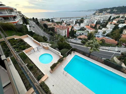 - une vue sur la piscine dans un bâtiment avec une ville dans l'établissement L'évidence, à Nice